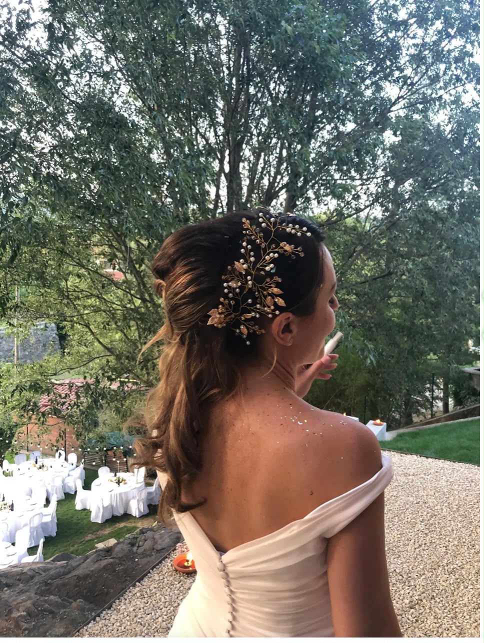 Sposa con coda morbida e accessorio dorato all'aperto